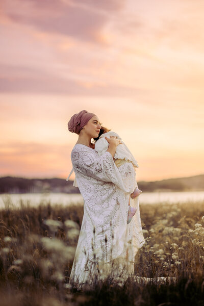 en mamma i hijab håller om sin dotter i famnen udner deras mdoerskapsfotografering