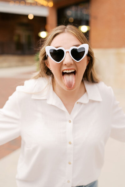 Event coordinator Madison wearing white sunglasses with tongue out