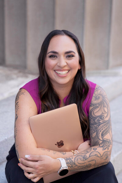Stephanie, Founder of BCWise Consulting, holding her laptop smiling 