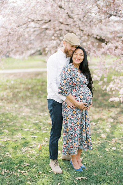 Brad Gillespie hugs his pregnant wife while she smiles at the camera in Goodale Park