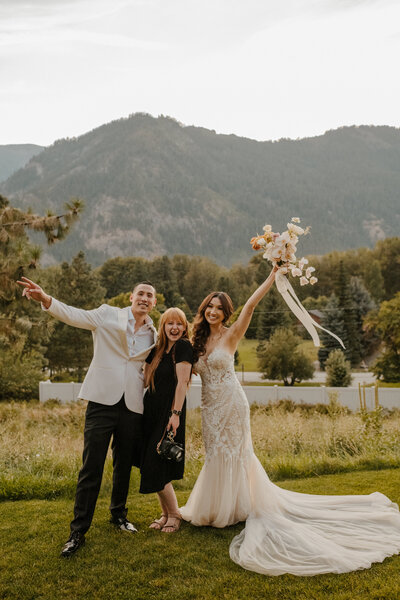 bride and groom smiling with photographer