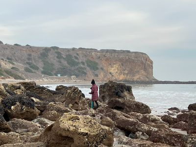 Girl walks on rocks at the beach