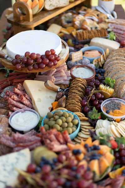 Large charcuterie board of cheeses, meats, and fruits,. 