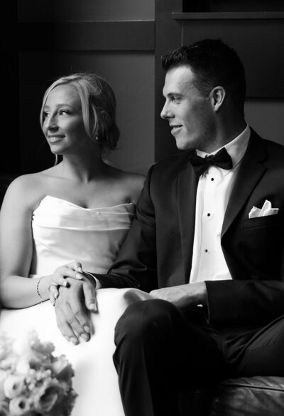 The groom and bride are looking at each other and embracing while standing near the altar