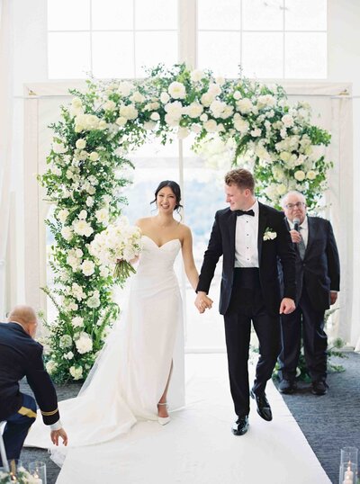 smiling bride and groom walk down the aisle after saying i do