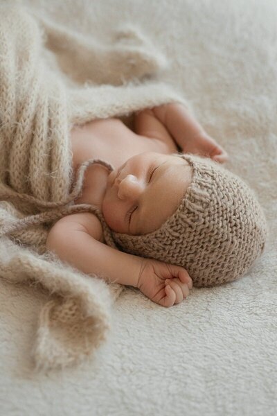 newborn sleeping in knit wrap photographed through Michigan photography