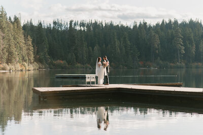 wedding portrait standing on dock of a lake