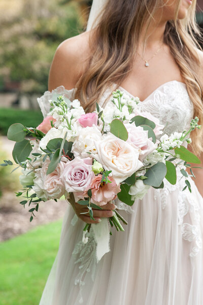 bride holding her white and pink bouquet of flowers during her summer west Michigan wedding