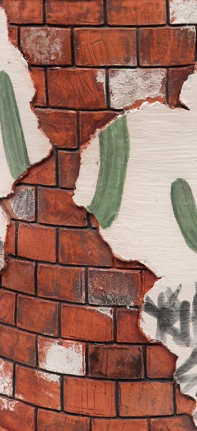 a close up image of the brick and broken wall texture that Krissy Ramirez creates with ceramic and underglazes