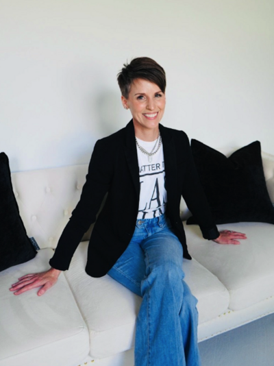 Jondrea smiling wearing a blazer of a graphic t-shirt