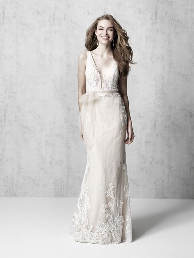 A translucent tulle bow accents the waistline of this sleeveless lace sheath.