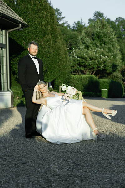 high-end bridal photos with bride sitting on chair and groom standing behind her