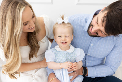 Baby smiling on mom and dad's lap