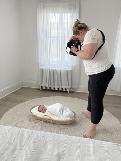 woman taking a photo of a newborn baby in a studio room in Pennsylvania