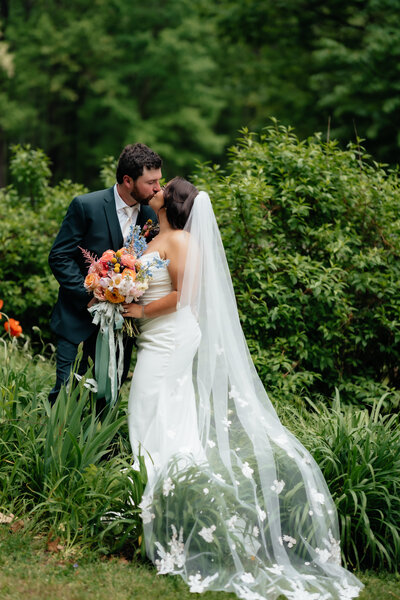 photo of bride and groom kissing outside taken by wedding photographer in virginia