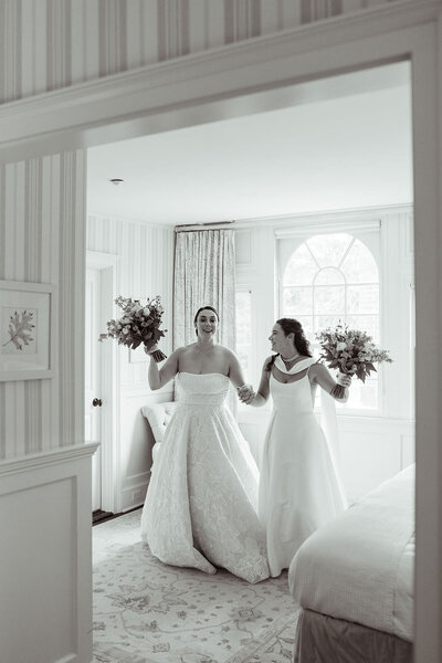 Brides smiling holding their wedding bouquets in hand