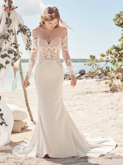 Long Sleeve Sheath Wedding Dress. Beautiful illusion cut-out sleeves accent this sleek and classy Chardon crepe wedding dress complete with a bateau neckline and sheath silhouette. Finished with covered buttons trailing down the back over zipper closure.