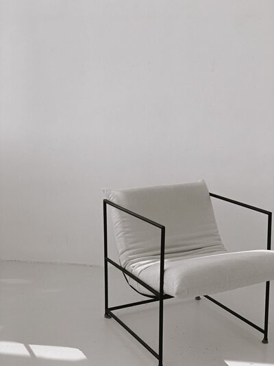 Black Steel and white fabric lounge chair in white studio