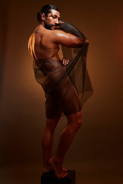 Dramatic portrait of Rolando Tamez wearing a textured, earthy outfit, captured by Ylva Erevall.
