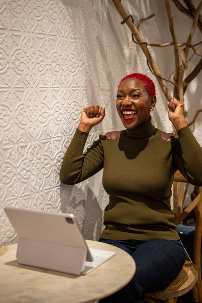 Nikisha happily helping her clients through her laptop