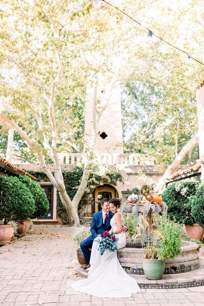 Tlaquepaque Weddings Bride and Groom sitting on side of water fountain