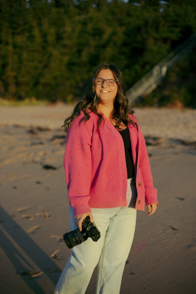 Canadian wedding photographer smiling at the camera on the beach