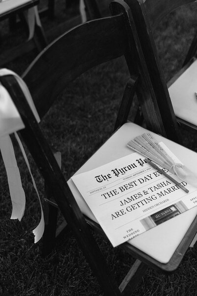 Black and white photo of a wedding ceremony chair with program, captured by a Utah wedding photographer.