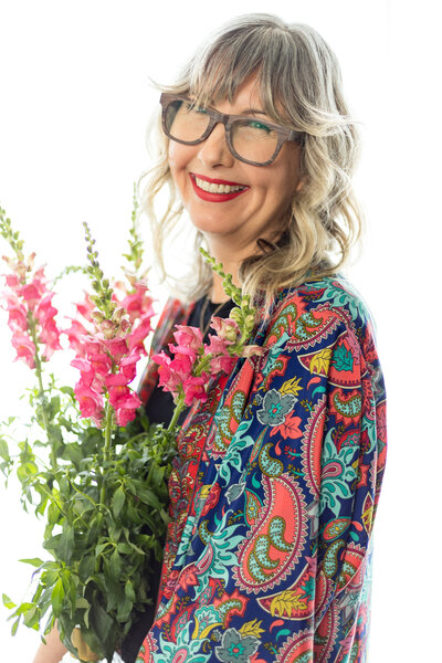 Lifestyle Headshot of woman holding pink flowers personal branding image