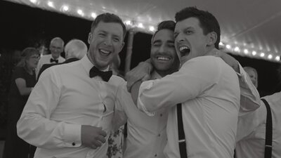 Groomsmen laugh on the dance floor.