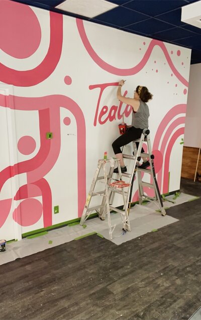 Rachel Sotak painting mural for Teatotaller, a local cafe and eatery in Concord, NH