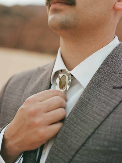 groom shows off bolo tie in southern utah elopement