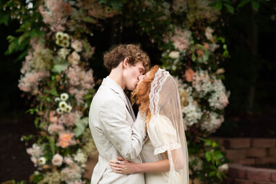 Bride and groom share their first kiss as newlyweds at their romantic backyard wedding in Richmond.