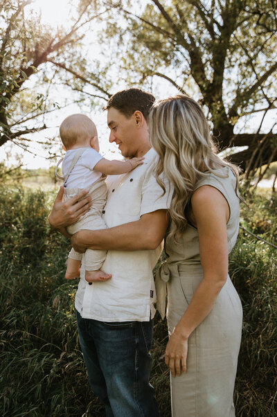mom and dad with baby at sunset taken by fargo wedding photographer kiella lawrence