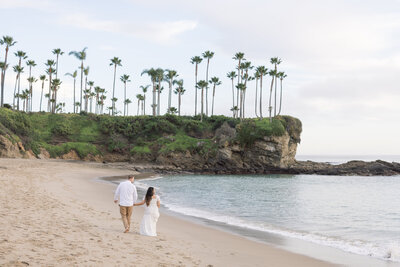candid maternity photo on the beach with palm trees