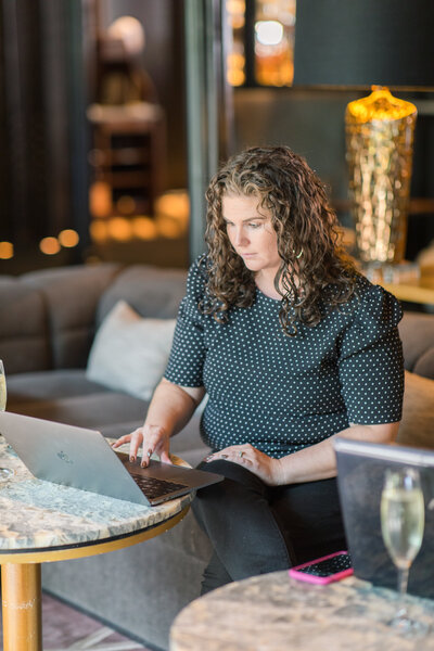 woman working on a laptop in hotel lounge at the Pendry in Baltimore Maryland