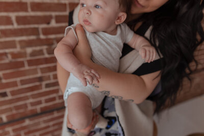 Mother cuddling newborn in family session in photography studio in Troy, Mo
