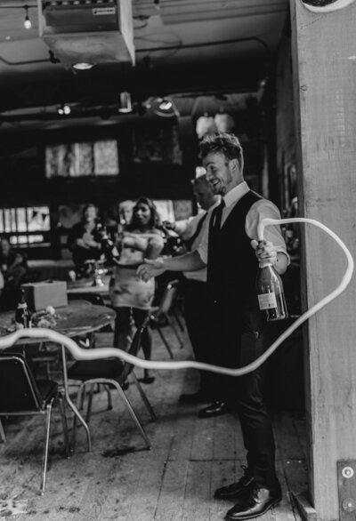 Groom pops the champagne at a Missoula MT Wedding