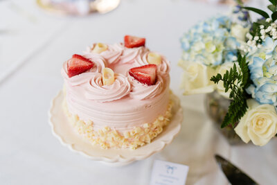 white and blue hydrangea flowers and pink strawberry cake for centerpieces.