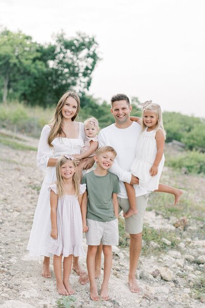 Mom and dad and 4 children smiling at one another during their newborn session with Dallas Newborn Photographer Amanda Carter