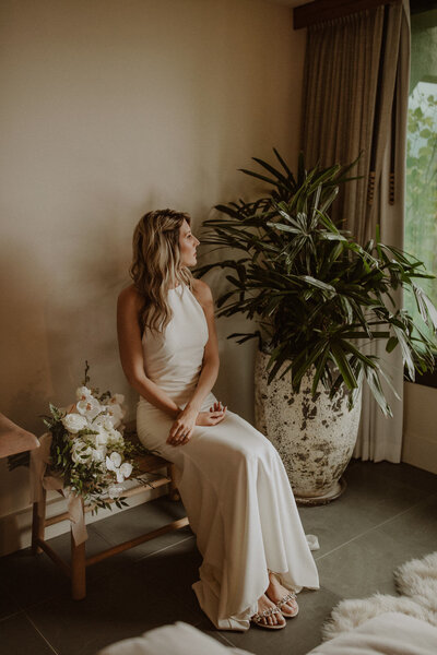 Bride sits with bouquet in the 1-Hotel Hanalei