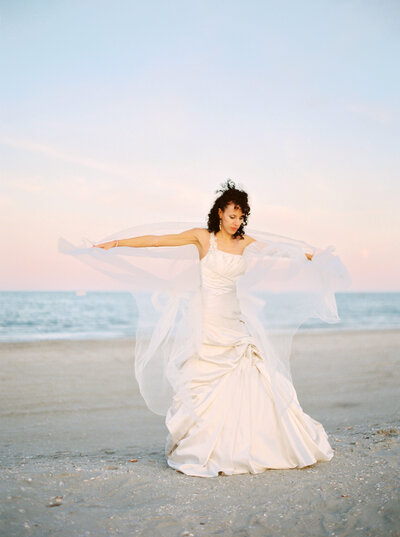 Bride spins on the beach in her wedding gown
