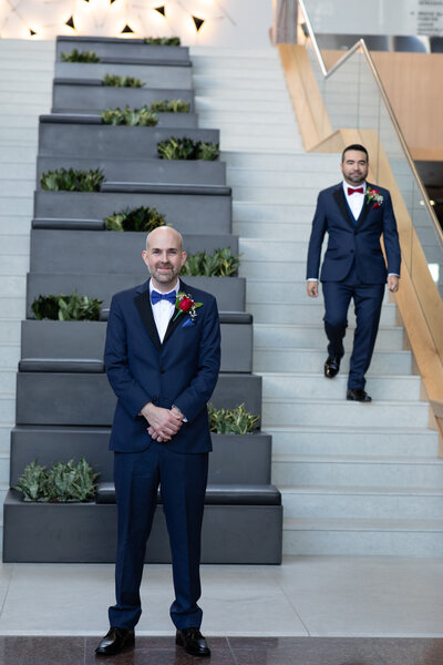 Two groomsmen standing on the stairs of a building, captured by an Austin-based wedding photographer.