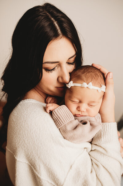 New momma takes in the sweetness and fleeting moments of her new baby during a newborn session at Nikii Pix Studios