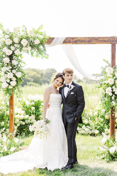 bride and groom posing together under an altar