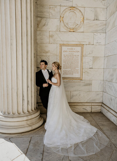 bride and groom standing by marble pillar in Cleveland Ohio