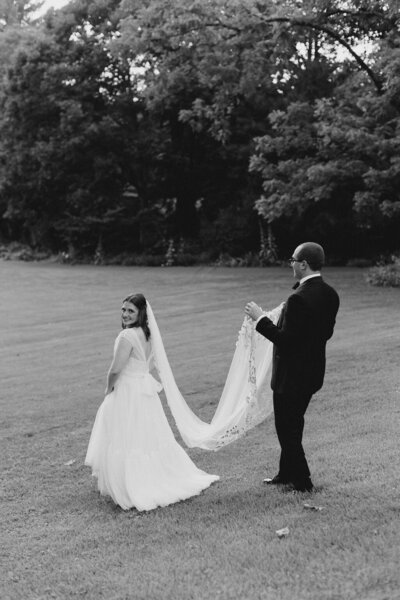 Groom stands with bride at outdoor venue in Virginia