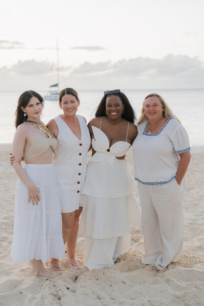 A group of friends traveling in Anguilla pose for a photo on the beach