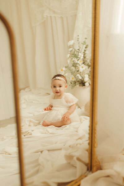 one year old girl with a floral crown and vintage dress in photo session in Nashville