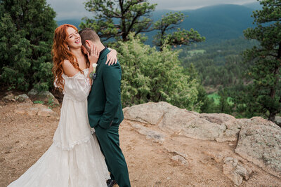 A bride and groom embrace in Leadville Colorado. The groom cries into the bride's shoulder