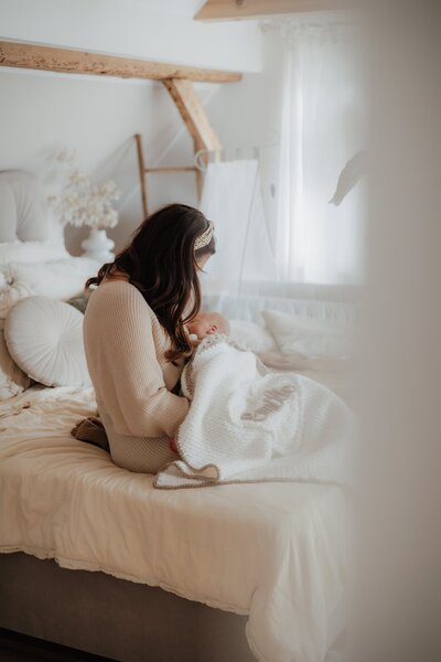 Mutter stillt Baby im Schlafzimmer, Home Shooting